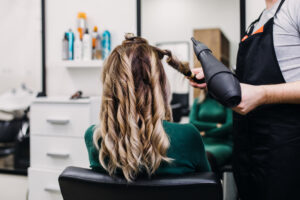 Beautiful hairstyle of mature woman after dying hair and making highlights in hair salon.